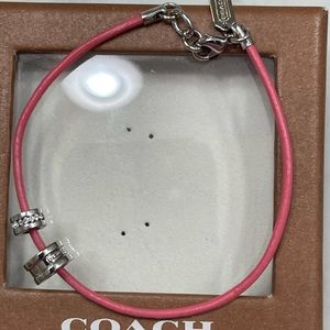 Coach pink leather cord bracelet with charms. New. Includes box.